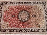 an image of a red and black rug on a white tiled floor