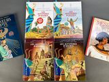 three books on a table, one of which has a picture of an egyptian man and two of which are