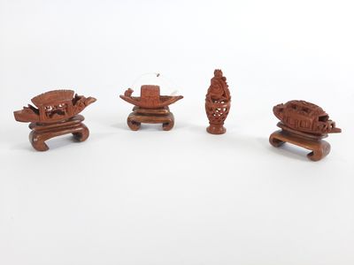 trois pièces de bois sculpté reposent sur une surface blanche