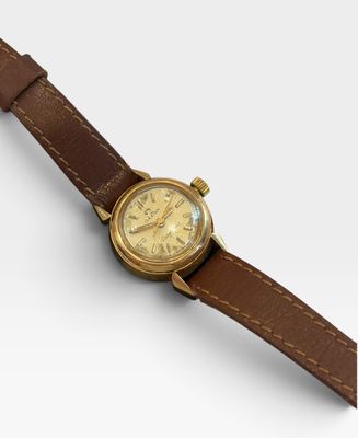 un gros plan d'une montre montée sur un bracelet en cuir marron