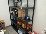 une étagère avec des bouteilles et des boîtes de conserves dans une pièce