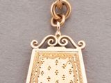 a close up of a gold necklace with a purse on it