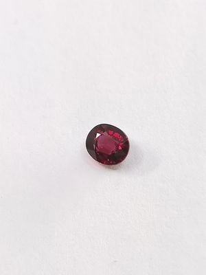 un gros plan d'un grenat rouge sur une surface blanche