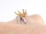 a person holding a gold and silver ring on their finger