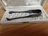 a silver spoon in a white box on a wooden table