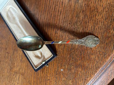 une cuillère posée sur une table, dans laquelle se trouve une autre cuillère