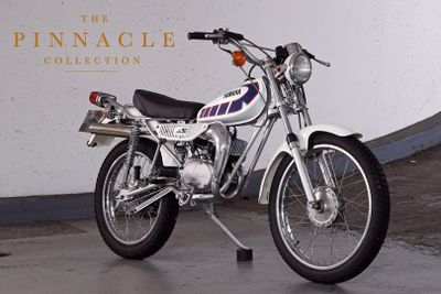 a motorcycle parked in front of the pinnacle collection sign