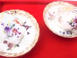 deux assiettes ornées de fleurs, posées sur un plateau rouge