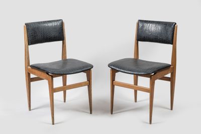 pair of chairs with black leather upholstered seats and wooden legs