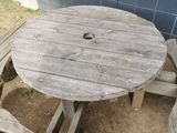 a wooden table and two benches on the ground