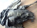 a statue of a bird with wings on a wooden table
