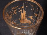 a glass with a boat on it sitting on a saucer