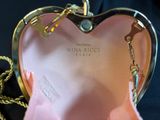 a pink purse with a gold chain hanging from it