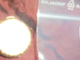 une petite montre de poche en or posée sur un tissu rouge