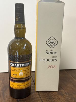 une bouteille de vin posée à côté d'une boîte sur une table en bois