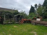 a horse drawn carriage parked in a yard next to a fence