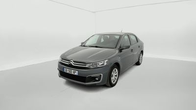 une voiture grise dans une pièce blanche au sol blanc