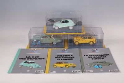 four toy cars in a display case on a table
