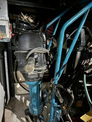 une photo d'une perceuse dans un garage où se trouvent de nombreux outils