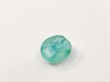 a green emerald stone on a white surface
