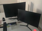 deux écrans posés sur un bureau, avec un clavier et une souris