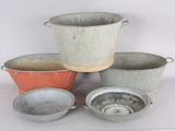 several metal pots and pans are sitting on a white surface