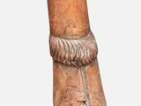 a small wooden object with a rope around it