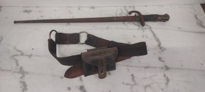 un couteau et une ceinture posés sur une table en marbre