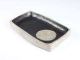 une assiette noire et blanche sur laquelle se trouve un point blanc