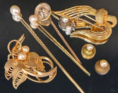 une broche en or ornée de perles et d'autres bijoux sur un fond noir