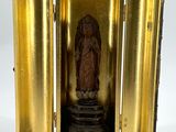 une petite horloge en or renfermant une statuette