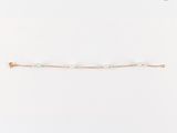 un bracelet de perles blanches sur fond blanc