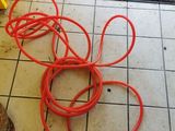 a bunch of red hoses on the floor next to a door