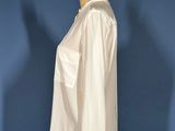 a white shirt on a mannequin stand against a blue wall