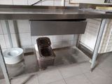 a sink in the middle of a stainless steel counter