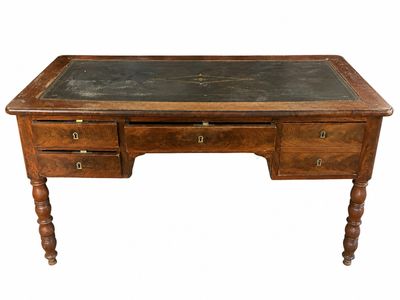 un vieux bureau en bois avec un plateau en marbre noir et des pieds en bois