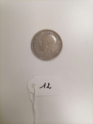 a close up of a coin on a white surface with a name tag