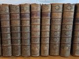 plusieurs vieux livres sont alignés sur une table en bois
