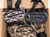 three fanny bags in a cardboard box on a white floor