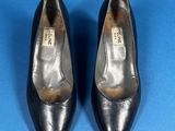 a pair of black leather shoes on a blue surface