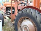 an old rusted tractor sitting in the grass