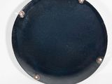a black plate with rivets on it on a white surface