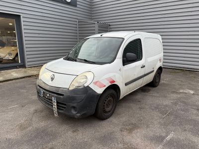 la petite camionnette blanche est garée devant un bâtiment