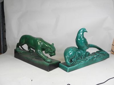 pair of green bookends of a cat and a dog on a rock