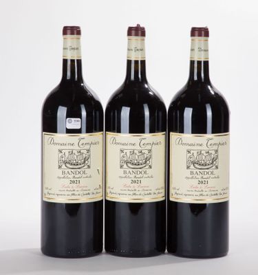 trois bouteilles de vin sont alignées sur une surface blanche