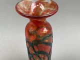 a glass vase with a red and green design on it
