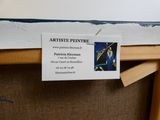 une pancarte au dos d'une chaise sur laquelle on peut lire « artist peitre »