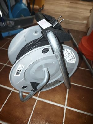 a cable reel that is sitting on a tile floor