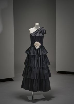 une robe noire posée sur un présentoir à mannequin dans une pièce