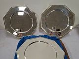 deux assiettes en argent et une serviette bleue sur une table